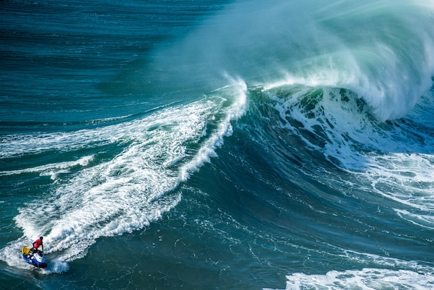 Olas espumosas del Océano Atlántico con un motociclista