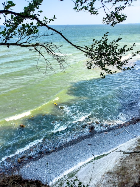 Foto gratuita olas en el mar cerca de la costa en una playa de guijarros vacía