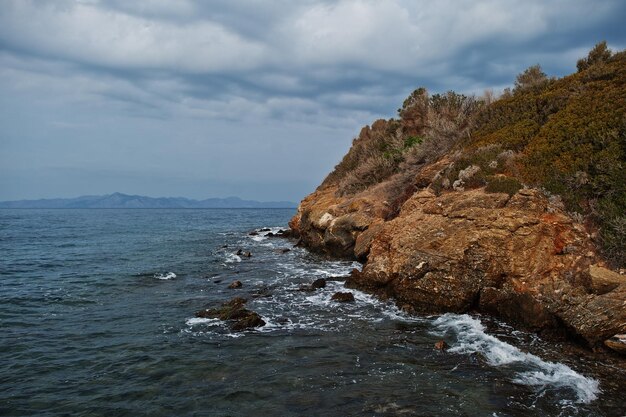 Las olas del mar rompen en el paisaje de rocas de la playa Las olas del mar chocan y salpican en las rocas en Bodrum, Turquía
