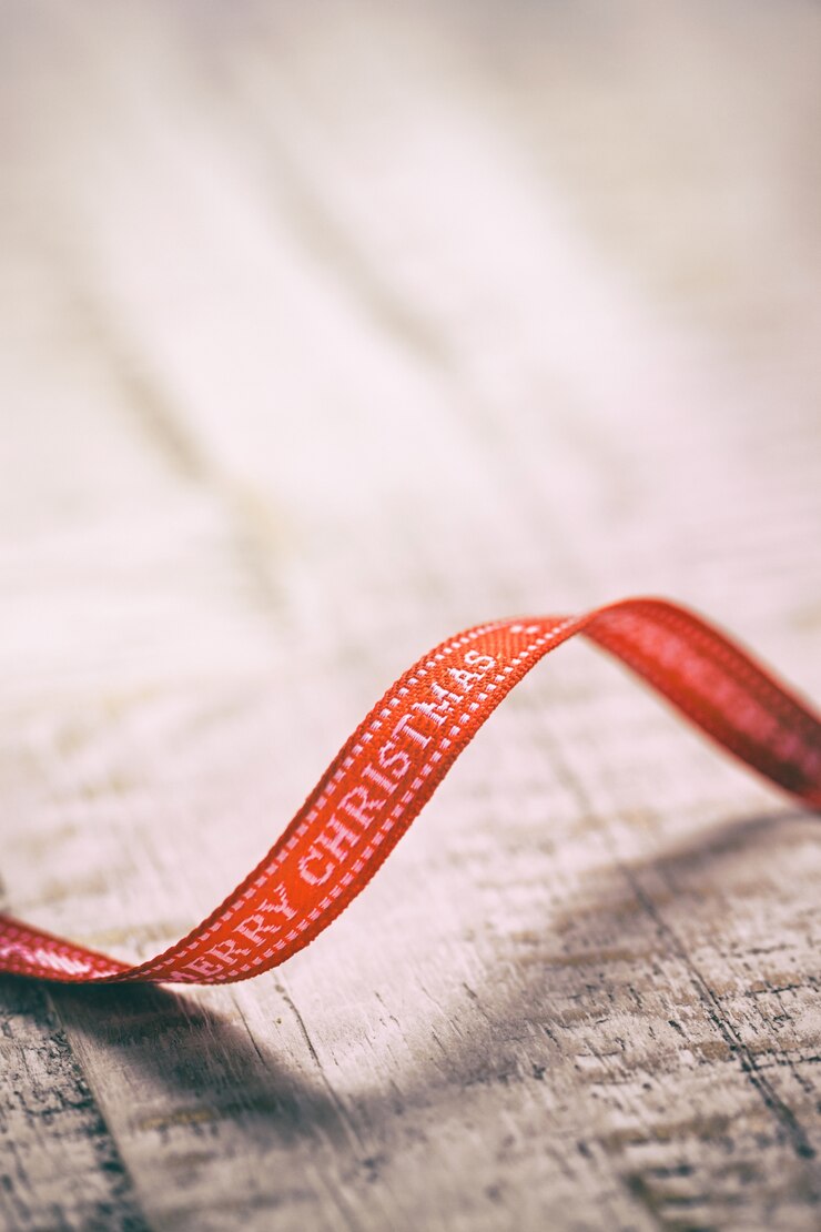 Photo Gratis old christmas concept - red ribbon with letters merry christmas on an old wooden background, closeup