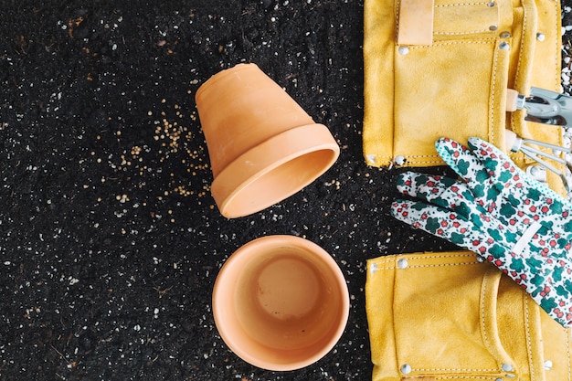 Ollas vacías cerca de la bolsa con herramientas de jardinería