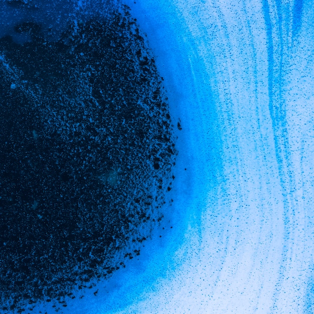 Ondas abstractas de espuma y burbujas en líquido azul