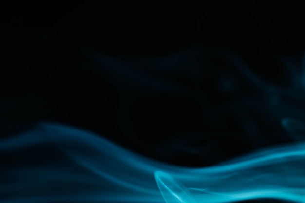 Ondas de humo azul sobre fondo negro