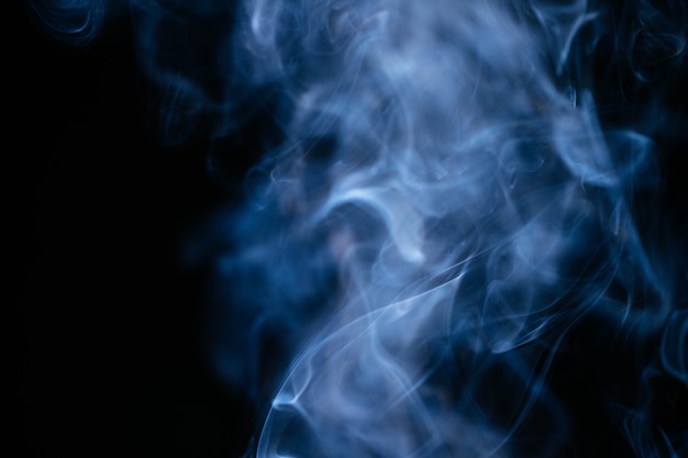 Ondas de humo azul sobre fondo negro
