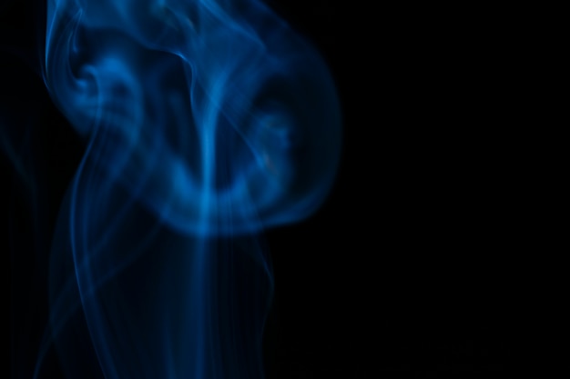 Ondas de humo azul sobre fondo negro