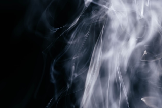 Foto gratuita ondas de humo gris sobre fondo negro