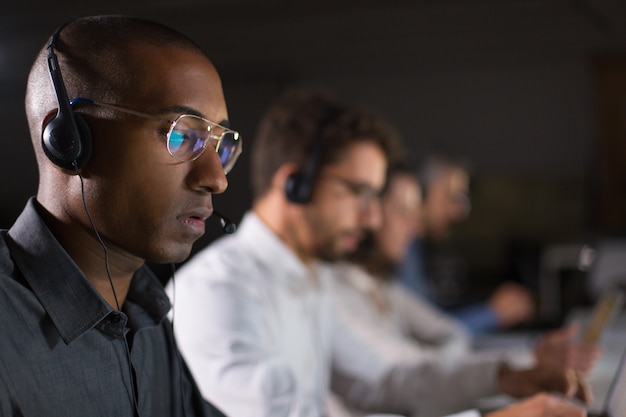 Operador de call center concentrado que se comunica con el cliente