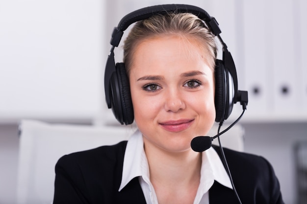 Operador femenino del teléfono de la ayuda de cliente en el lugar de trabajo