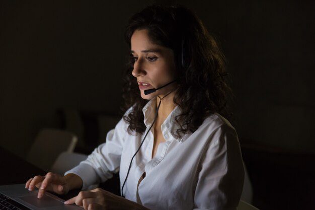 Operador serio de call center en oficina oscura