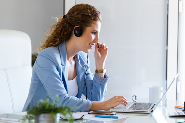 Operador de servicio al cliente hablando por teléfono en la oficina.