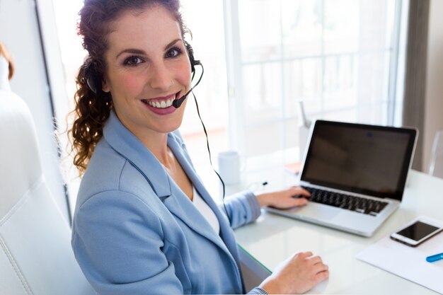 Operador de servicio al cliente hablando por teléfono en la oficina.