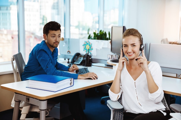 Operador de teléfono de soporte femenino hermoso joven hablando, consultoría, sobre oficina