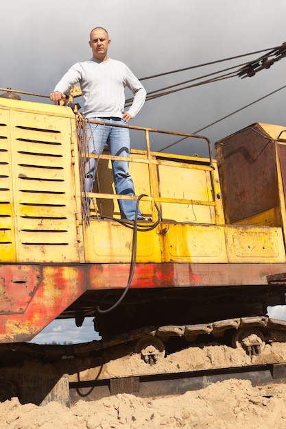 Foto gratuita operador de tractor en el pozo de arena