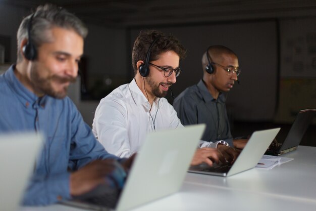 Operadores de call center alegres durante el proceso de trabajo