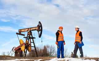 Foto gratuita operadores de petróleo hablando en campo de petróleo
