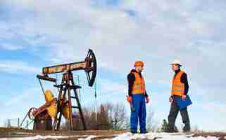 Foto gratuita operadores de petróleo hablando en campo de petróleo