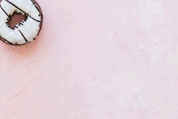 Foto gratuita opinión de alto ángulo del buñuelo blanco del chocolate en fondo rosado