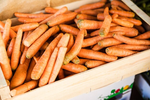 Opinión de alto ángulo del cajón anaranjado de la zanahoria en el mercado vegetal