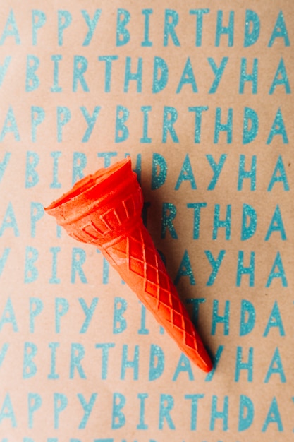 Foto gratuita opinión de alto ángulo del cono de helado vacío en el papel del regalo del feliz cumpleaños
