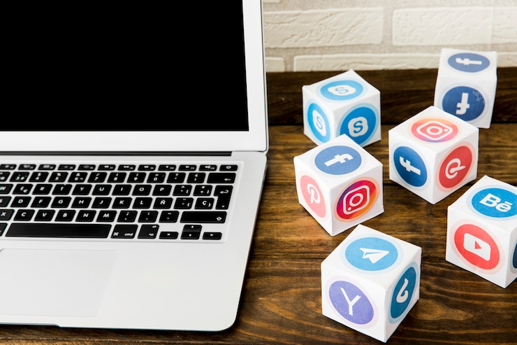 Foto gratuito ordenador portátil cerca de cajas de iconos de aplicaciones sociales en la mesa