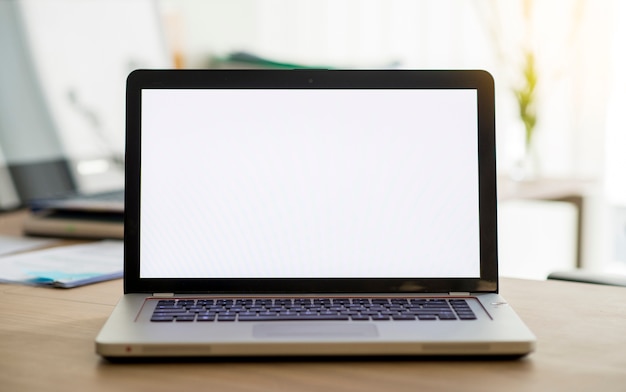 Ordenador portátil con pantalla en blanco sobre escritorio