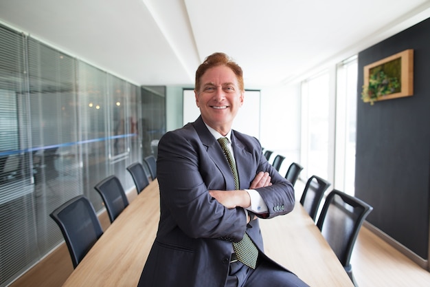 Foto gratuita orgulloso hombre de negocios de mediana edad en la sala de conferencias