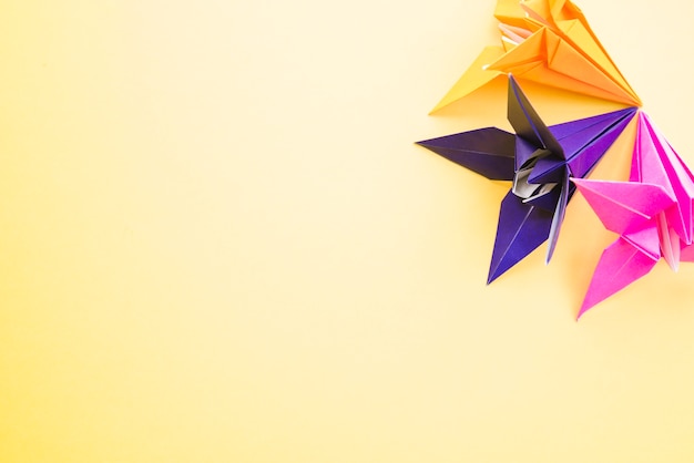Foto gratuita origami coloridas flores de papel sobre fondo amarillo
