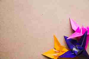 Foto gratuita origami coloridas flores de papel sobre fondo de textura de cartón