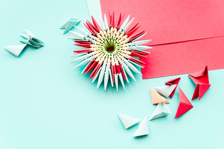 Foto gratuito origami de flor de papel hecho a mano sobre fondo verde azulado