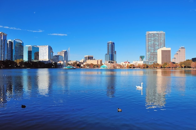 Orlando Lake Eola por la mañana con rascacielos urbanos y cielo azul claro con cisne.