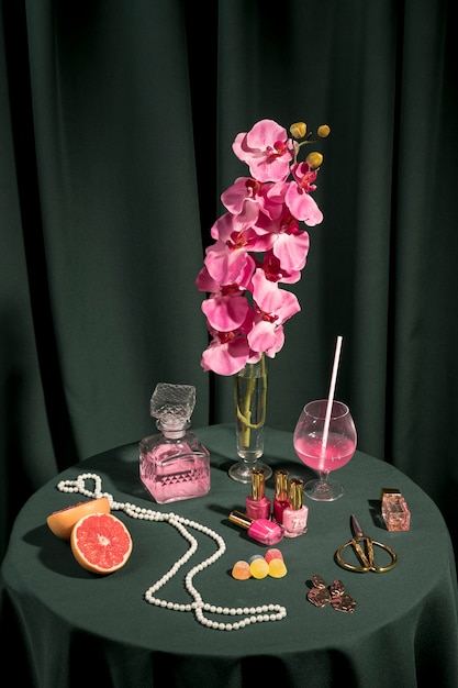 Orquídea rosa de alto ángulo junto a artículos de moda.