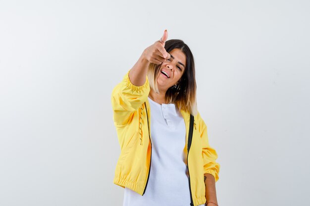 Ortrait de dama apuntando a la cámara en camiseta, chaqueta y mirando confiada vista frontal