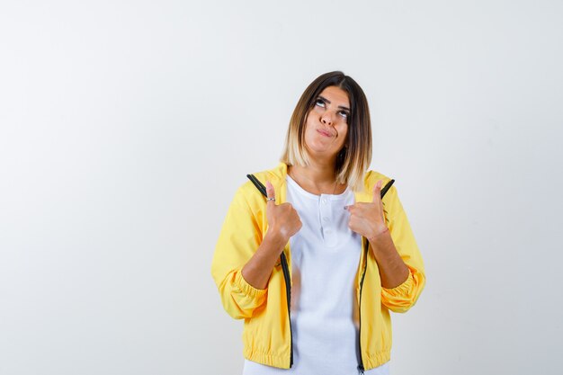 Ortrait de mujer apuntando a sí misma en camiseta, chaqueta y mirando vacilante vista frontal