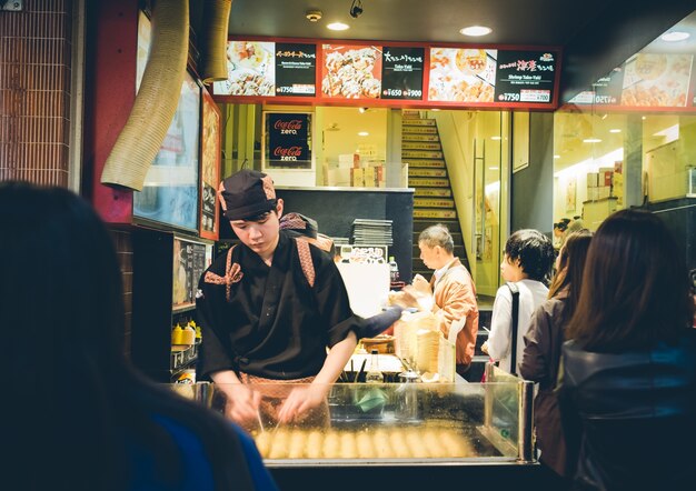 OSAKA, JAPÓN - septiembre, 1: Los cocineros no identificados preparan takoyaki