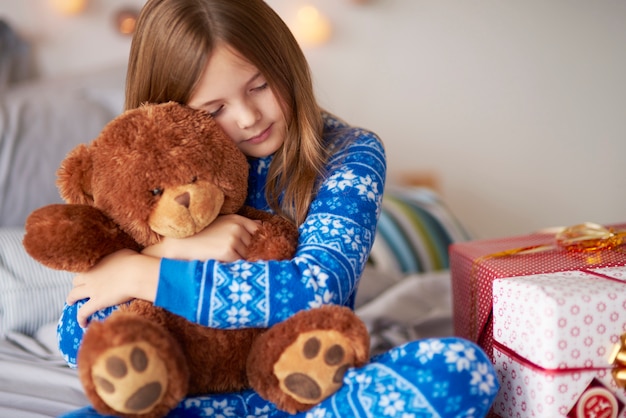 Foto gratuita oso de peluche de unión de niña pequeña en navidad