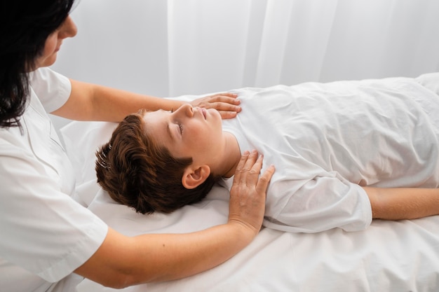 Osteópata femenina tratando a un niño en el hospital