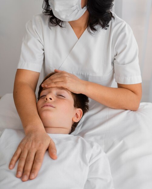 Osteópata femenina tratando a un niño en el hospital