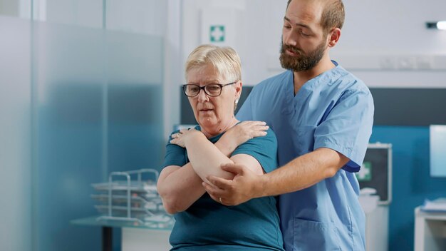 Osteópata rompiendo huesos en fisioterapia de rehabilitación, ayudando a la anciana con medicina alternativa en la cita de rehabilitación. Médico que trata al paciente con dolor en la médula espinal.