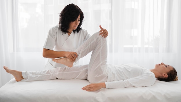 Osteópata tratando a una mujer joven en el hospital.