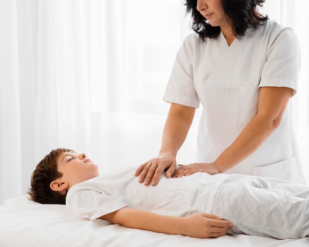 Osteópata tratando a un niño masajeando su barriga