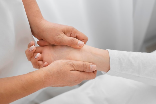 Osteópata tratando el primer plano de los brazos del paciente