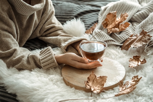 Otoño bodegón niña sosteniendo una taza de té.