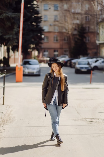 Ã Â oung niña bonita camina por la ciudad sonriendo y posando