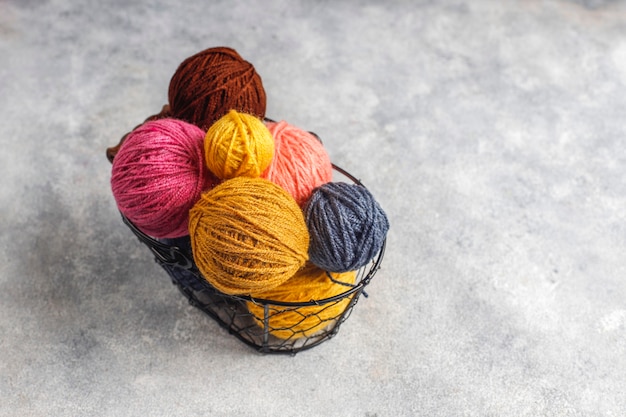 Ovillos de lana de diferentes colores con agujas de tejer.