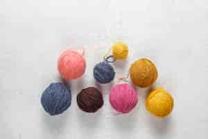 Foto gratuita ovillos de lana de diferentes colores con agujas de tejer.