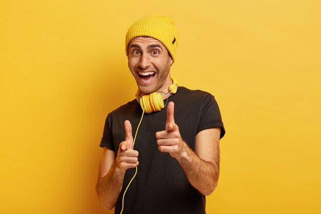 ¡Oye, eres elegido! Hombre alegre feliz señala con el dedo índice a la cámara