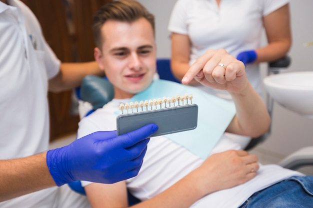 Paciente apuntando a los dientes con el dentista