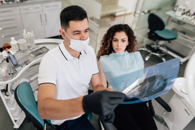 Paciente y dentista mirando radiografía