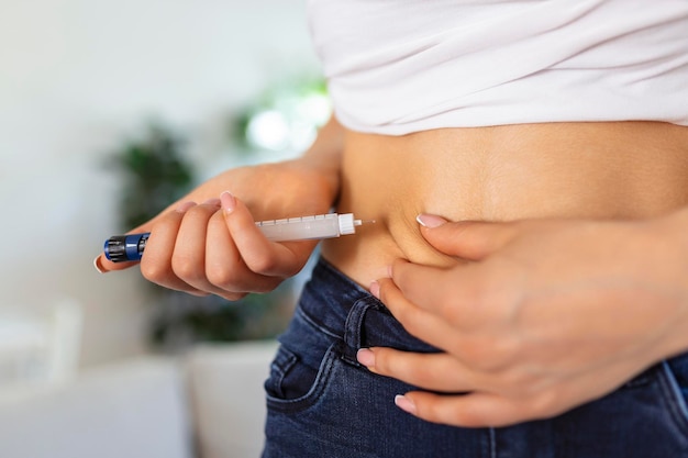 Foto gratuita un paciente diabético que usa una pluma de insulina para inyectarse insulina en casa una mujer joven controla la diabetes estilo de vida diabético