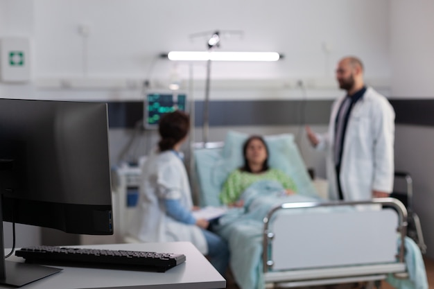 Paciente enfermo descansando en la cama usando un tubo de oxígeno nasal mientras habla con los médicos tratamiento médico ...